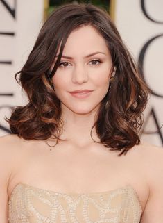 a woman in a strapless dress poses for the camera on the red carpet at an event