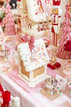 a table topped with gingerbread houses covered in frosting and sprinkles