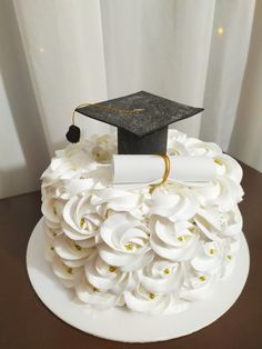 a cake with white flowers and a graduation cap on top