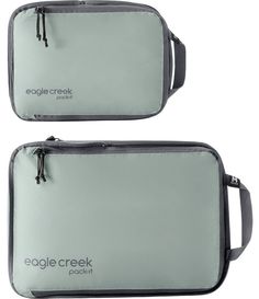 two gray bags sitting next to each other on top of a white surface with the words eagle creek printed on it