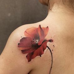 a woman's shoulder with a flower tattoo on it