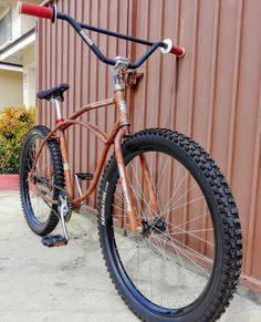 a brown bike parked next to a building