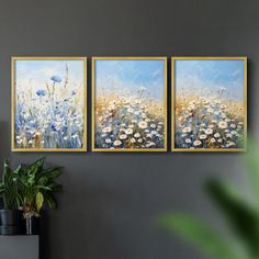 three paintings hanging on the wall next to a potted plant