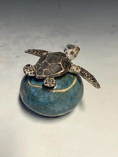 a small turtle sitting on top of a blue bowl