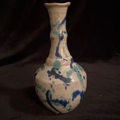 a blue and white vase sitting on top of a black table