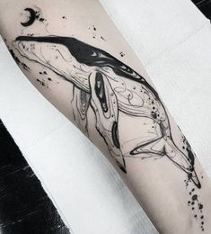 a black and white whale tattoo on the arm