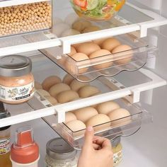 an open refrigerator with eggs and condiments on the shelves, as well as other food items