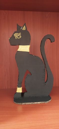 a black cat sitting on top of a wooden shelf