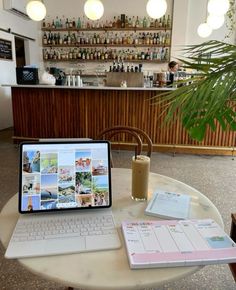 an open laptop computer sitting on top of a table next to a drink and menu