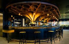 a bar with several stools in front of it and lights hanging from the ceiling