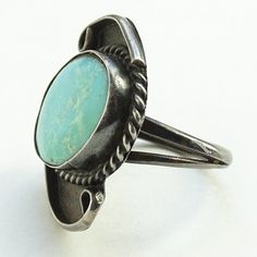 This is an Old Native American Navajo Ring Light Blue Turquoise Stone Size 6 3/4 Sterling Silver. The ring is handmade and the light blue turquoise oval stone is plain bezel set surrounded by rope twist wire and long curved wire swirls The shank is cold chisel split and there is natural age patina/dark tarnish. The ring face measures 1 1/4 inch by 1 inch. The ring weighs 6.3 grams and tests positive for sterling silver (unmarked). #2464225 Southwestern Adjustable Turquoise Ring, Southwestern Style Turquoise Ring With Patina, Adjustable Artisan Turquoise Ring With Concho, Adjustable Southwestern Turquoise Ring Nickel-free, Adjustable Southwestern Turquoise Ring Nickel Free, Nickel-free Southwestern Round Turquoise Ring, Nickel-free Round Southwestern Turquoise Ring, Adjustable Southwestern Style Turquoise Ring Nickel Free, Nickel Free Round Southwestern Turquoise Ring