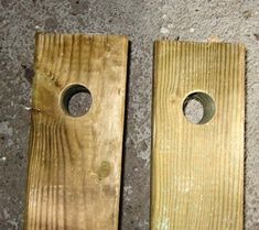 two pieces of wood sitting next to each other on the ground with holes in them