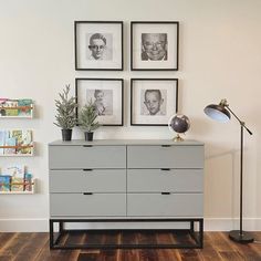 a dresser with three pictures on the wall above it and a lamp next to it