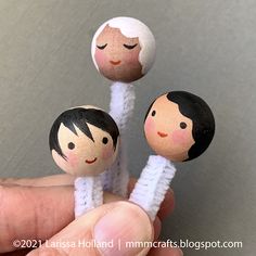 three little dolls are sitting on top of each other in the shape of people's heads