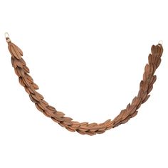 a necklace made out of wooden leaves on a white background