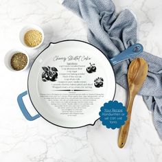 two bowls and spoons are sitting on a marble counter top, next to a recipe book