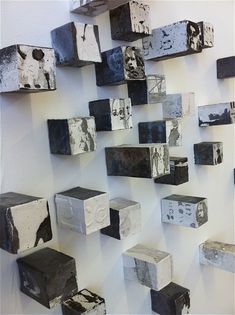 several cubes are hanging on the wall in an art gallery