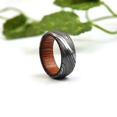 a wooden ring sitting on top of a table next to a green leafy plant