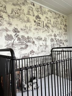 a baby crib in front of a wall with a mural on it's side