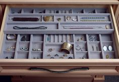 a drawer filled with lots of jewelry on top of a table