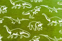 an image of dinosaurs on green paper with white stencils in the middle