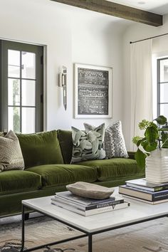 a living room filled with green couches and books on top of a coffee table