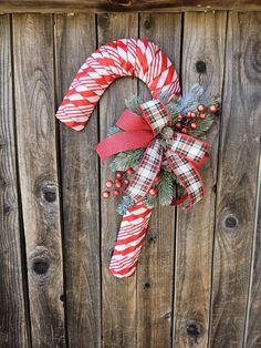 a candy cane wreath on top of a wooden fence