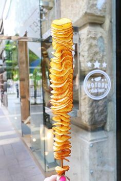 a person is holding up some food on a stick