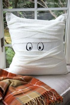 a pillow that has been made to look like a face on the side of a window sill