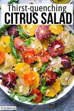 Multi-colored orange slices and grapfruit slices with arugula and sliced red onions on white plate. Title: Thirst-quenching citrus salad.