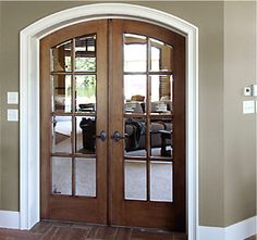 a large wooden door with glass panels on the front and side doors to both sides