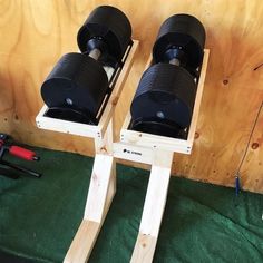 two black binoculars sitting on top of a wooden stand