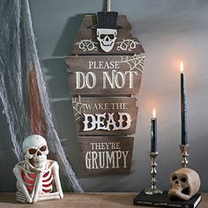 a table topped with candles and skeletons next to a sign that says don't be afraid