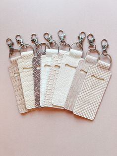 five different types of key chains on a pink surface