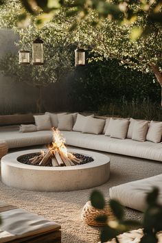 an outdoor fire pit surrounded by cushions and pillows