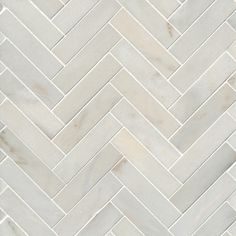 white marble herringbone tile pattern with dark grout and light brown veining on the edges