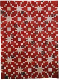 a red and white quilt with stars on it