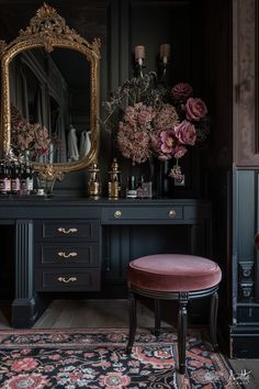 a black vanity with pink flowers on it and a gold framed mirror in the corner