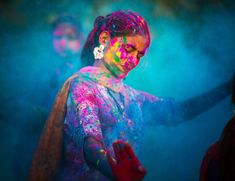 a woman covered in colored powder is dancing