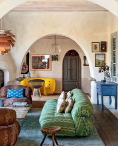 a living room filled with furniture and a fire place in the middle of an archway