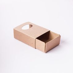 an open cardboard box sitting on top of a white surface with a hole in it