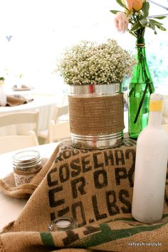 the table is set up with flowers and bottles on it, including an empty bottle