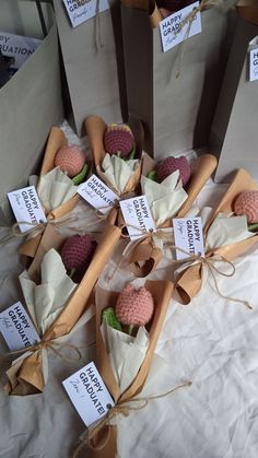 several small cones with raspberries in them are wrapped in brown paper and tied together