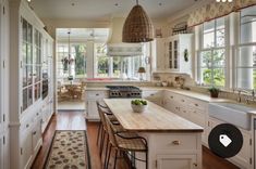 a large kitchen with white cabinets and wooden counter tops, along with an area rug on the hardwood flooring