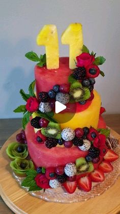 a cake with fruit on top and the number one made out of watermelon