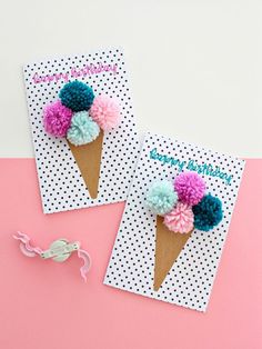 two ice cream cones decorated with pom - poms