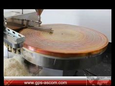 a machine that is cutting wood with a large circular object in the middle of it