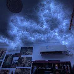 the ceiling is covered in blue clouds and pictures on it's sides, as well as an air conditioner