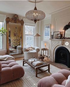 a living room filled with furniture and a fire place under a chandelier in front of a fireplace