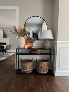 a table with two baskets on it in front of a mirror and a light fixture